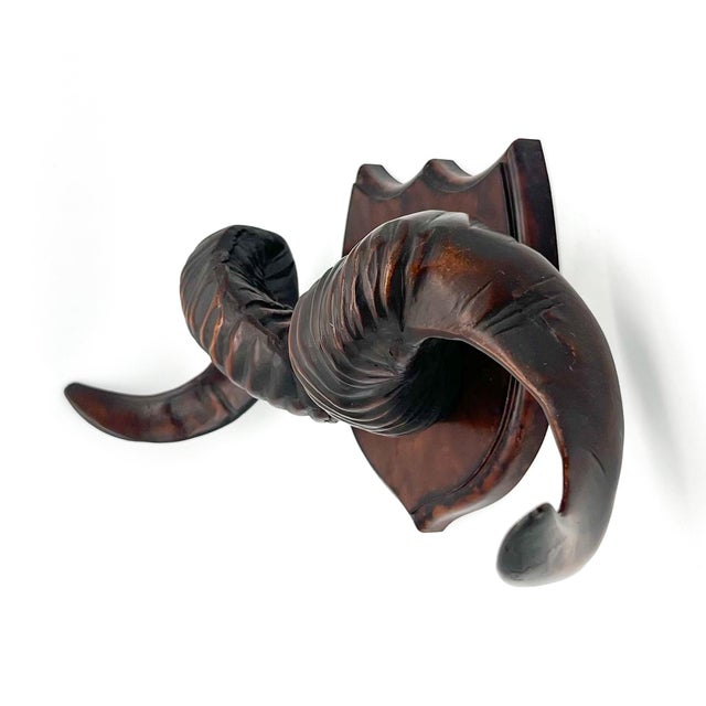 A striking, sculptural wall piece featuring a pair of sweeping ram horns cast in a single, solid resin form and finished...