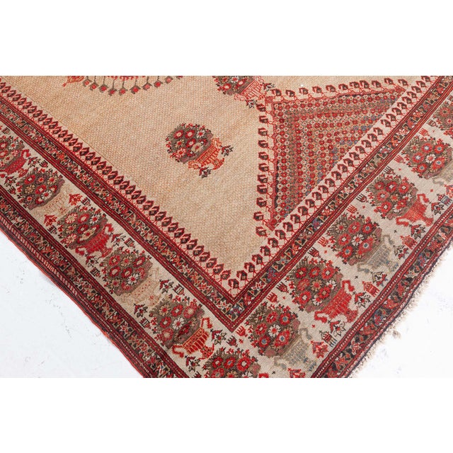 A late 19th century Sarouk rug, having a beige field with an orange and red central geometric medallion surrounded by...