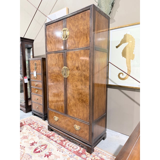 A statement-making Drexel Heritage armoire showcasing dramatic burlwood veneers framed by a rich dark wood case. Inspired...