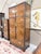 A statement-making Drexel Heritage armoire showcasing dramatic burlwood veneers framed by a rich dark wood case. Inspired...
