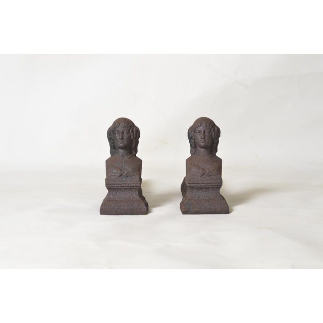 Pair of 19th-century cast iron andirons. Height 19 cm. Width 9 cm. Depth 32 cm. Signs of wear and age.