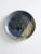 This is a signed studio pottery plate. The hand-crafted plate features a leaf and branch imprint with a striking blue and...