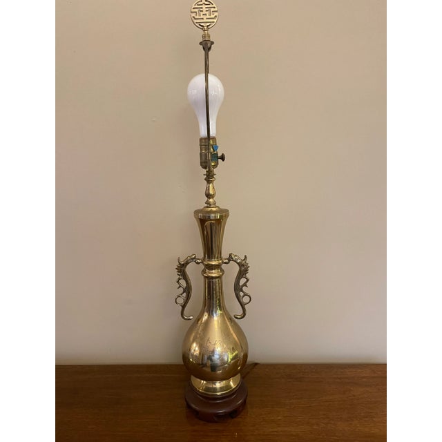 This vintage brass lamp features dragon shaped handles and showcases delicate etchings of birds and flowers. The lamp has...