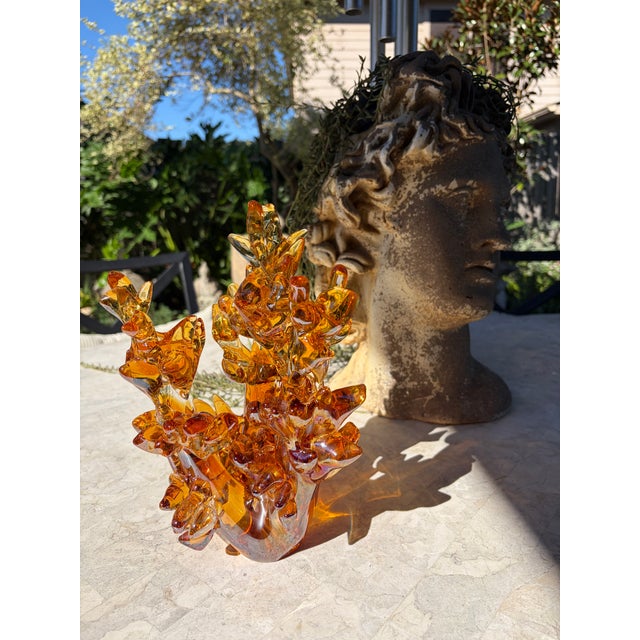 Striking vintage amber art glass sculpture featuring an elaborate arrangement of hand-formed floral and organic elements....