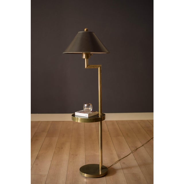 Mid Century Modern sculptural brass floor lamp with an attached round side table by Hart Associates, circa 1960's. This...