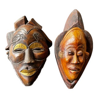 Two Carved Wood African Mask With Gilded Eyelids and Lips and Brass Decorations For Sale
