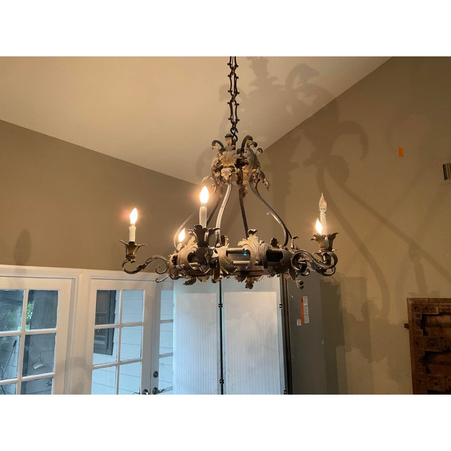 An impressive Naos Forge hand-forged iron chandelier, featuring elaborate scrolling ironwork, dimensional acanthus and...