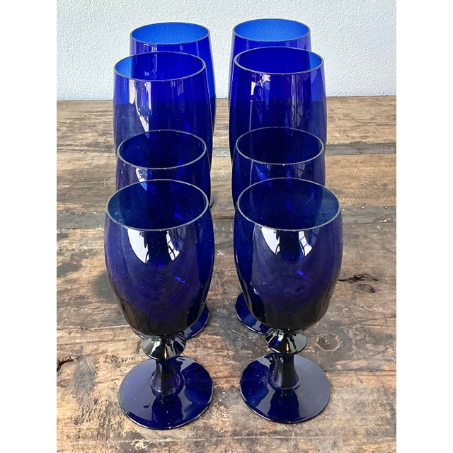 Infuse your next dinner party with the striking jewel tones of this exceptional set of eight vintage cobalt blue stemware...