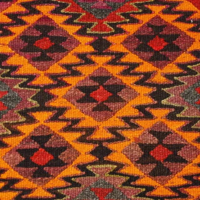 An early 20th Century Persian kilim runner with brilliant orange, crimson, and violet criss-crossing geometric pattern...