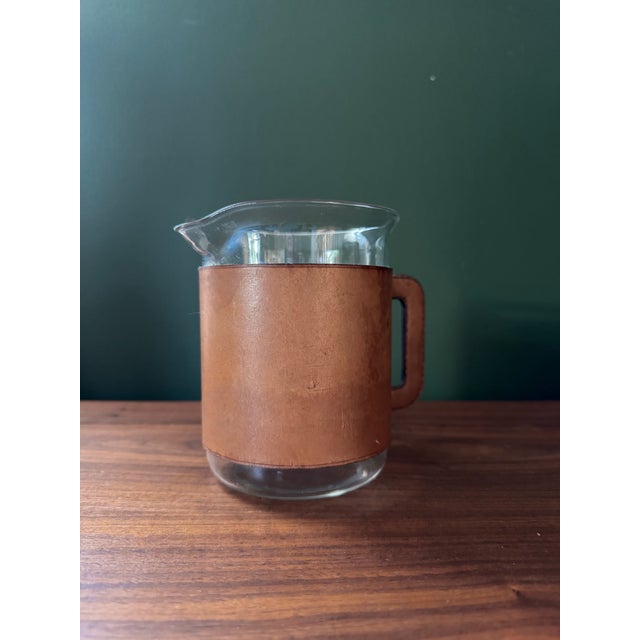 Rare 1950s leather wrapped glass bar pitcher by Austrian designer Carl Auböck. Measurements do not include handle