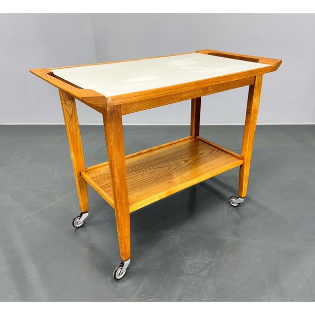 Mid century serving troley or side table on wheels, made of wood with plywood top. Good original condition with some signs...