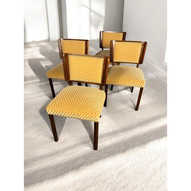 A high-quality set of four German chairs from around 1930, crafted from solid mahogany with upholstered seats and backs....