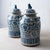 A pair of Chinese blue and white glazed stoneware jars, each with a domed lid surmounted by a seated Buddhist lion, or foo...
