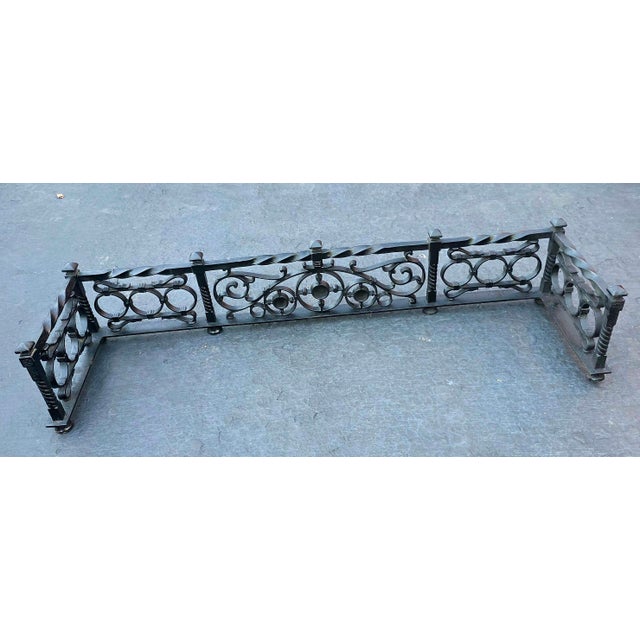 Vintage wrought Iron fireplace fender with Scrollwork and geometric patterns along the panel, a twisted center top rail,...