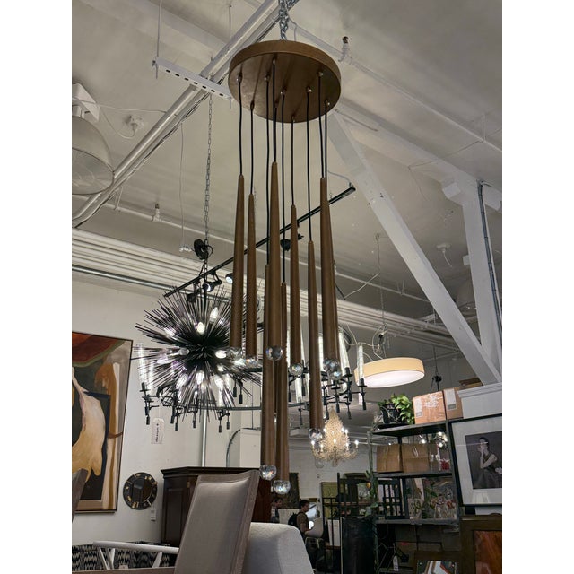Design Plus Gallery presents a Ten-Light Pendant Chandelier in the style of Jonathan Browning. A circular bronze-toned...