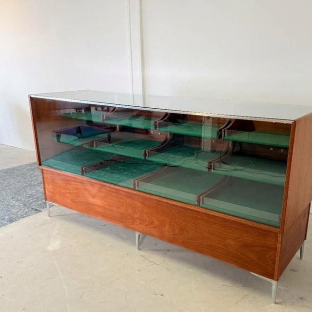 Crafted in Germany during the 1960s, this architectural display counter pairs rich mahogany veneer with a minimalist six-...