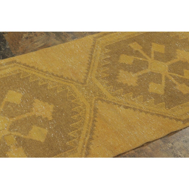 Hand-knotted in wool, this vintage 3x13 Turkish extra-long runner, circa 1950–1959 features a sequence of oversized...