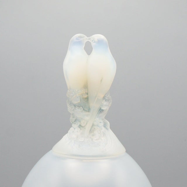 Tourterellès' an opalescent glass vase by Rene Lalique. Milky opalescence vase with a pair of intertwined lovebirds over...