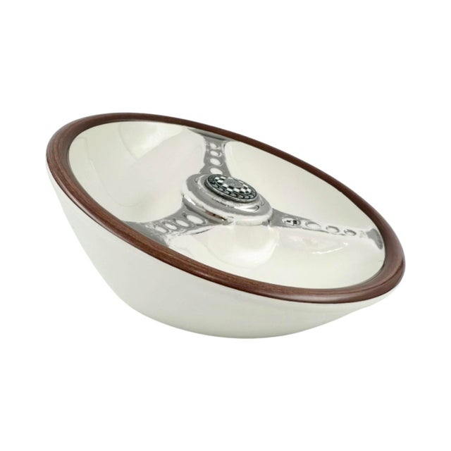 A well-executed ceramic ashtray modeled after a classic Jaguar steering wheel, centered with the marque’s emblem set...