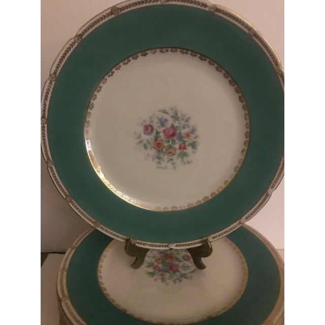 A set of KPM Berlin porcelain Dinner Service Plates. The floral centers with apple green borders with decorative gold...