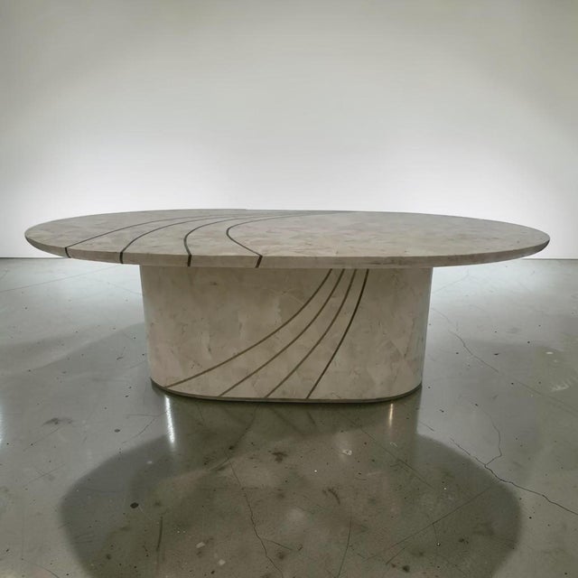 Beautiful vintage tessellated stone coffee table, oval in shape. This table has brass inlay on the top and on the base, in...