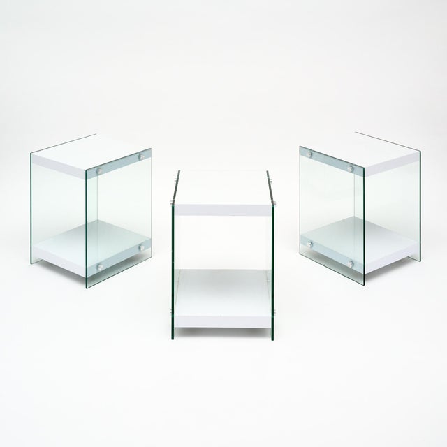Set of three side tables from France in the modernist style. Each table is supported by glass sides with chrome finials...