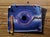 Wormhole by Patrick Nevins | Oil on board Painting of a black hole on a torn paper background For Sale