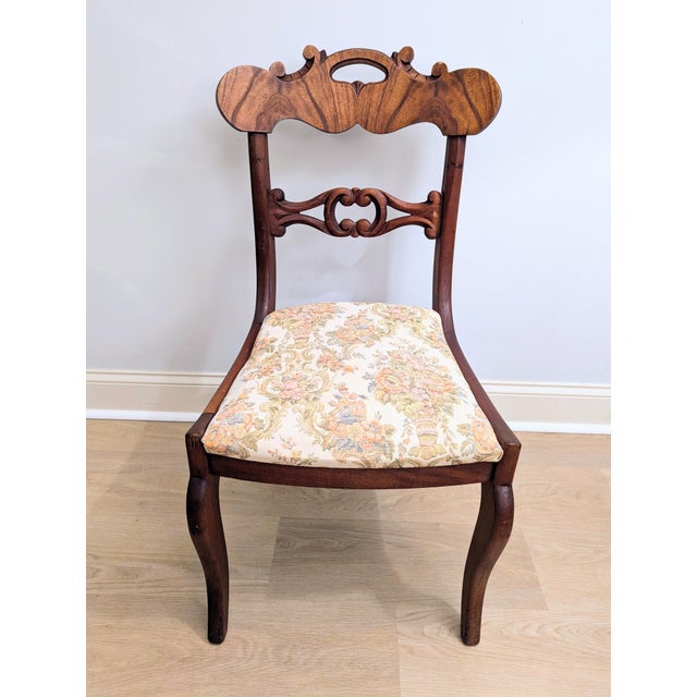 This gorgeous mahogany parlor chair features a "hoop" or "balloon" back with a prominent curved crest rail that is carved...