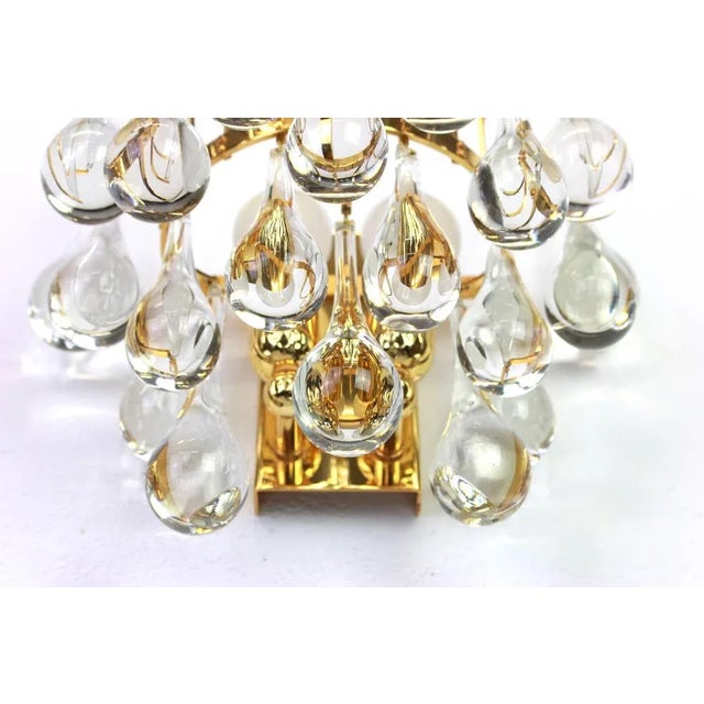 A stunning pair of golden sconces, made by palwa, germany, circa 1970-1979. It’s composed of murano teardrop crystal glass...