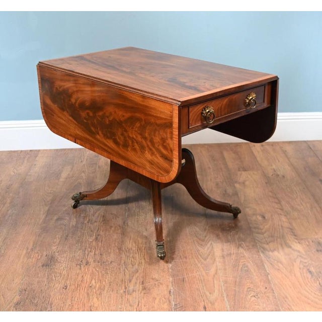 Regency drop leaf breakfast table circa 1810 Flame Mahogany top with satin crossbanding around edges Supported on column...