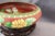 Beautiful Vintage cloisonne bowl, with carved teak stand, circa 1980s. The bowl has a rust red background with an overall...