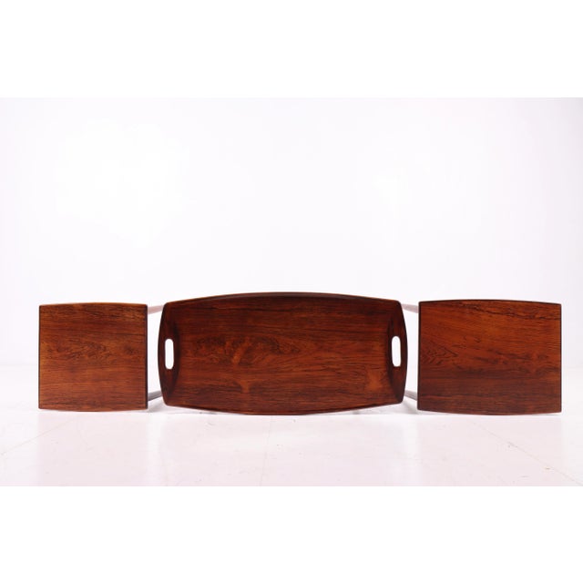 Set of elegant nesting tables crafted in dark wood with solid wood legs. The tabletops feature a clean and simple design,...