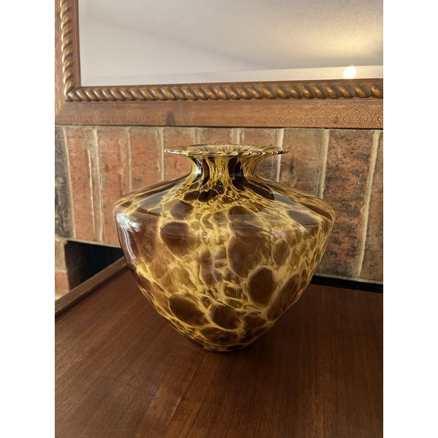 Crafted in a warm amber tone, this beautiful vase features aventurine glass—a classic technique where fine metallic flecks...