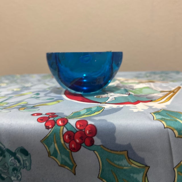 This heavy, multi-faceted art glass bowl features a captivating deep blue core submerged in clear glass, created using the...