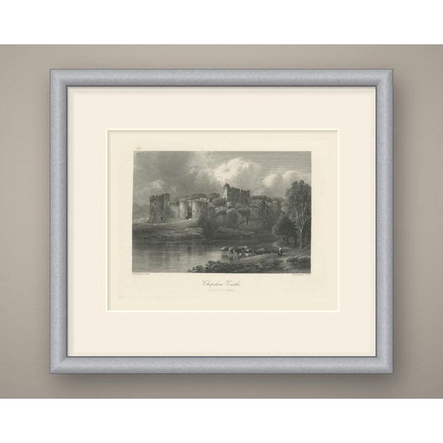 The long, ivy-hung walls of Chepstow Castle stretch along a rocky bank above still water in this steel engraving. Round...