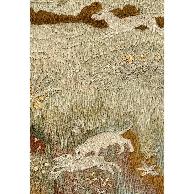 A charming 19th-century English crewelwork depicting a lively rural scene with a leaping stag, coursing hounds, rabbit,...
