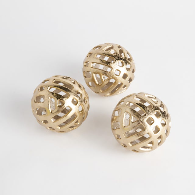 Weighted nicely in a cast aluminum open design, this set of 3 orbs makes for a dynamic bowl filler. Finished in a warm...