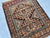 A rare antique Timuri Baluch tribal mat from the Khorasan region — a bold stepped rectilinear cruciform medallion with...