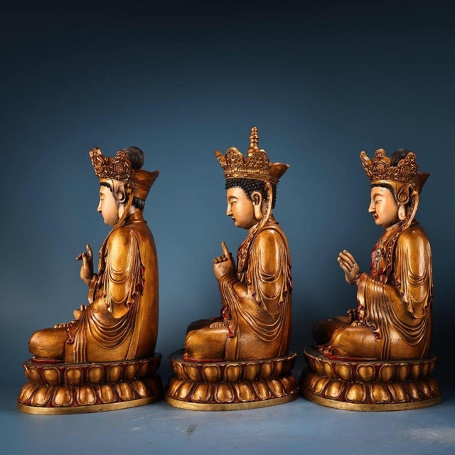This elegant set of three gilt bronze figures depicts seated Bodhisattvas, each seated in a meditative lotus position upon...
