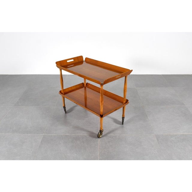 Stylish and restored service cart with double plywood shelf folded on the sides, with wheels and brass finishes. Italian...