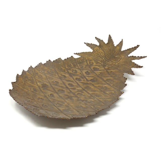 A vintage, handmade steel tray or platter, in the form of a pineapple. It is covered in gold lacquer and has three ball...