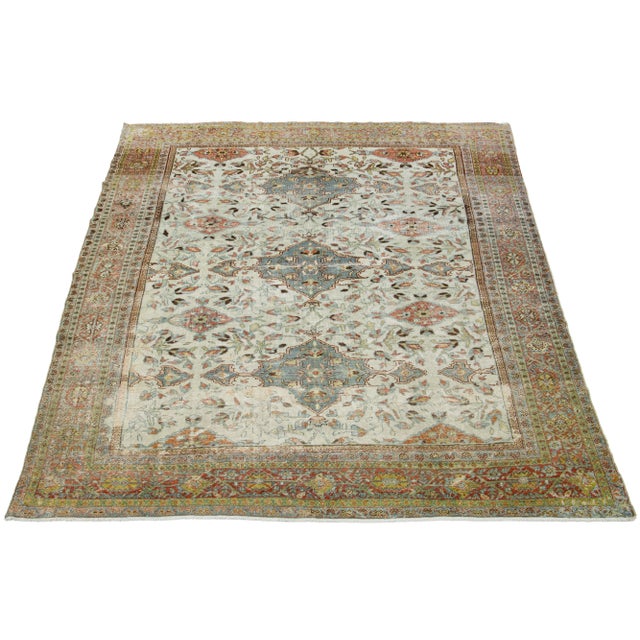 This is a beautiful Antique Mahal hand-knotted wool rug with a beige-colored field. The floral motif of this Persian rug...