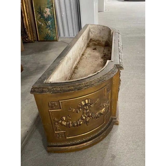 Beautiful French jardiniere in plaster and wood with bows and garland, 19th century. Antique gold finish. No decoration on...