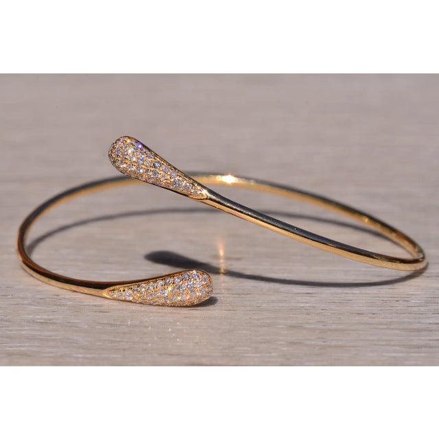 The Korbel: Yellow Gold Flexible Diamond Bangle Bracelet. The bracelet features a bypass style design with each end pave...