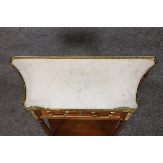 Graceful, refined, and unmistakably French in inspiration, this exceptional Maison Jansen style marble top console table...