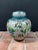This antique handmade cloisonné lidded ginger jar features a brightly colored floral design against a white enamel...