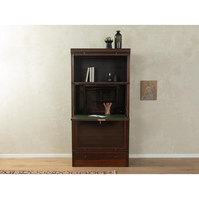 Wonderful secretary from the 1960s. High-quality three-part body made of dark-stained oak with a hinged writing surface, a...