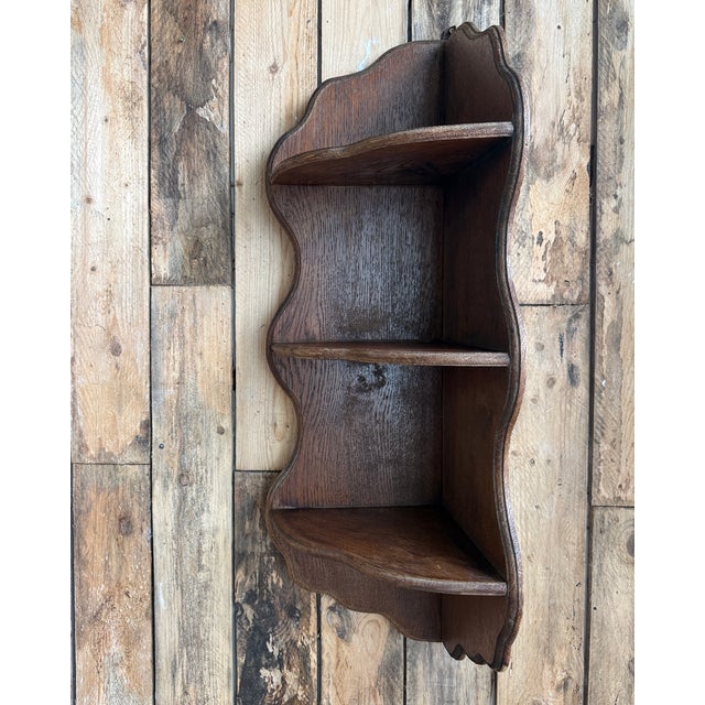 This antique corner shelf in solid oak dates from the late 19th or early 20th century. Designed to hang in a corner, it...
