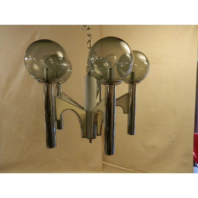 Elegant and modern five light chandelier with smoked glass globes. Angular chrome body shape. Lovely for any dining room...