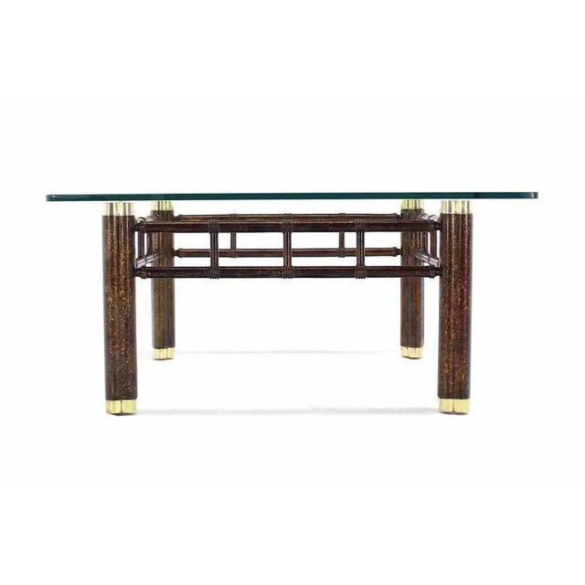 Nice tortoise finish with brass feet base coffee table with thick glass top. Made in the early 20th century.